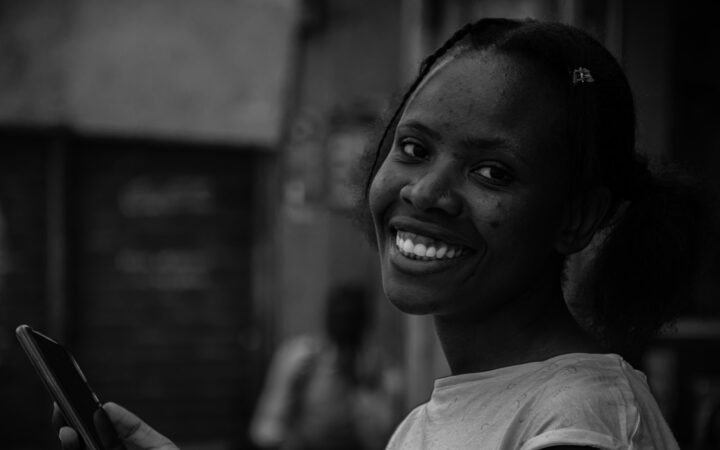 Une femme souriante tenant un téléphone portable